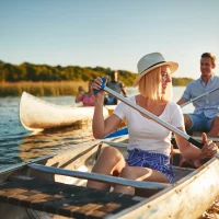 laughing-young-woman-canoeing-on-a-lake-with-frien-2023-11-27-04-56-54-utc.jpg-min